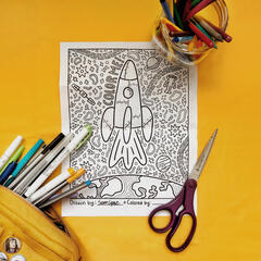 An overhead shot of a coloring page of a spaceship.
